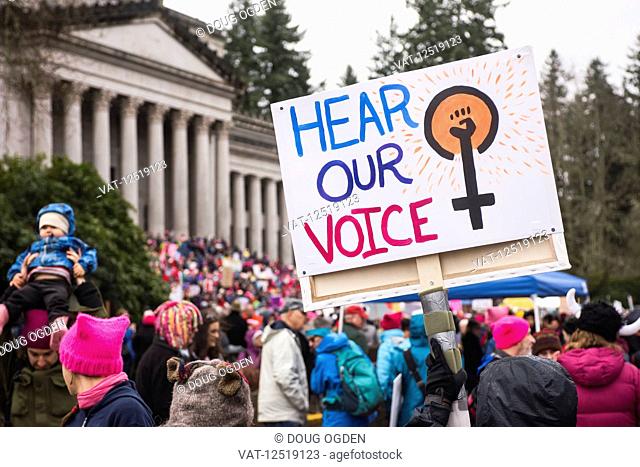 Protesters and sign at the 2018 Women's Day March in Olympia at the Washington State Capitol; Olympia, Washington, United States of America