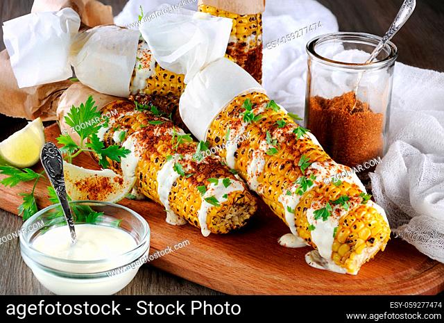Delicious fried corn, grated with lime, poured with sauce and seasoned with spicy spices. Indian and Mexican style