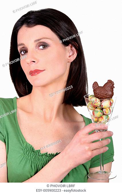 Woman holding a glass full of mini chocolate eggs