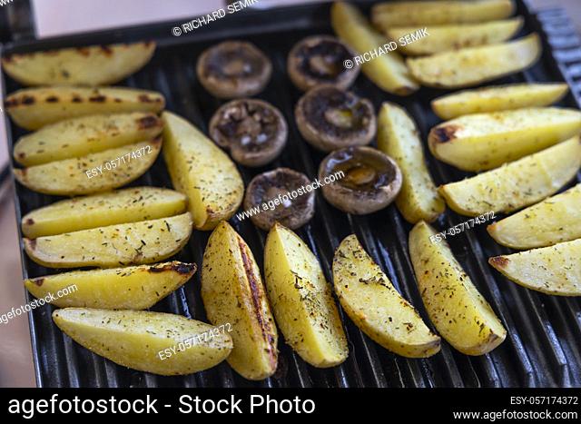 Electric grill with spicy potatoes and mushrooms