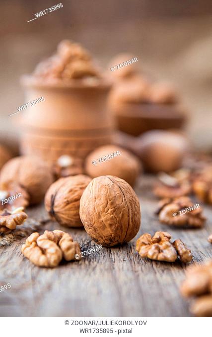 Walnuts in wooden bowls on wooden table