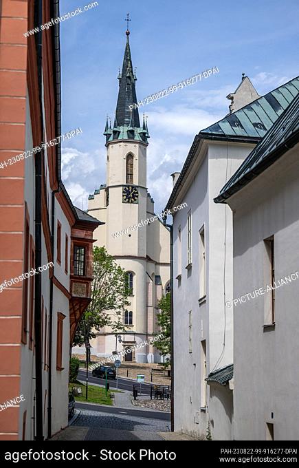 15 August 2023, Czech Republic, Jáchymov: The tower of the church of St. Joachim and St. Anna can be seen in the center of the old mining town of Jáchymov...