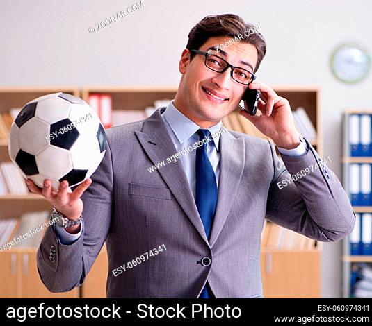 The businessman with football ball in office