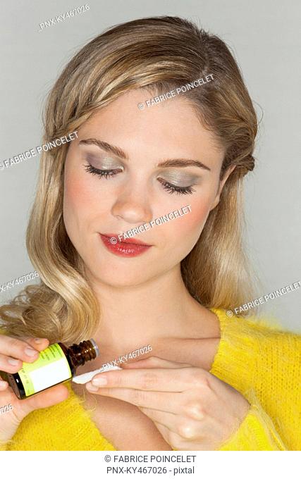 Close-up of a beautiful woman holding essential oil