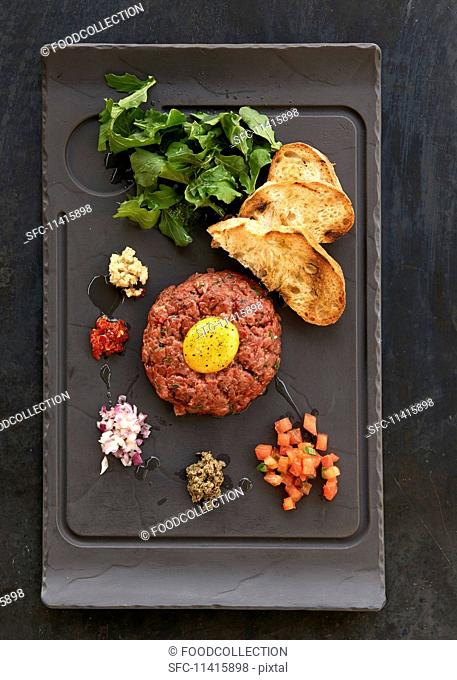 Beef tatar with an egg yolk and grilled bread