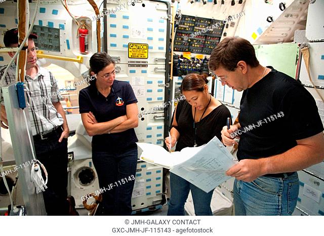 NASA astronauts Nicole Stott (second left) and Michael Barratt (right), both STS-133 mission specialists, participate in a training session in an International...