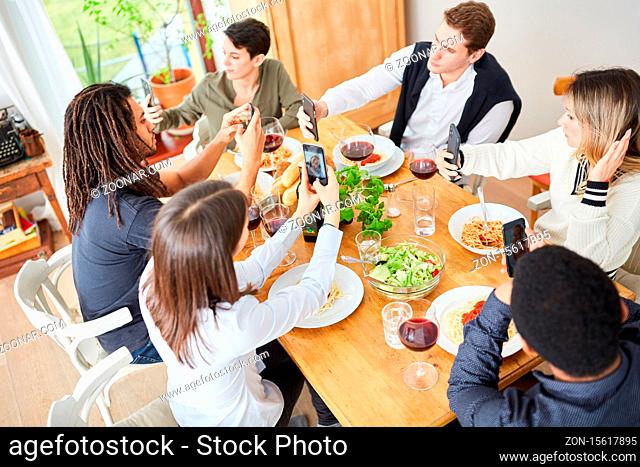 Unhöfliche Freunde schauen alle auf ihr Smartphone beim Mittagessen am Tisch