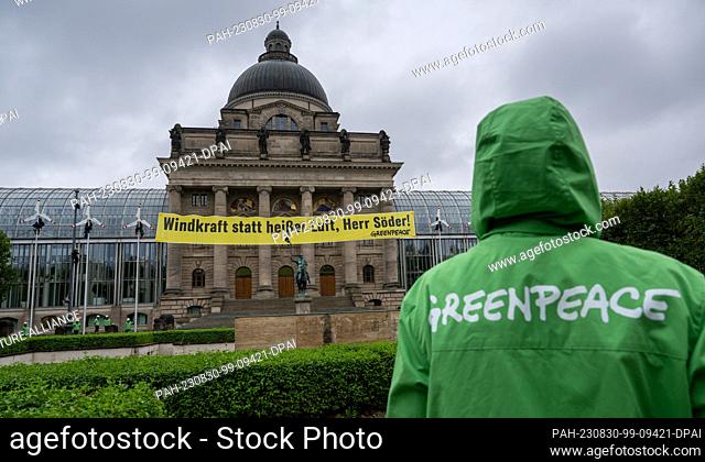 30 August 2023, Bavaria, Munich: Activists from Greenpeace climbed the flagpoles in front of the Bavarian State Chancellery in the early hours of the morning to...
