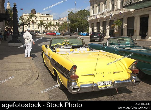 Old American cars used as taxis parked at parking lot in front of the colonial buildings in Center Havana, La Habana, Cuba, West Indies, Central America