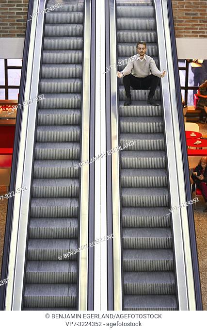 man sitting on escalator