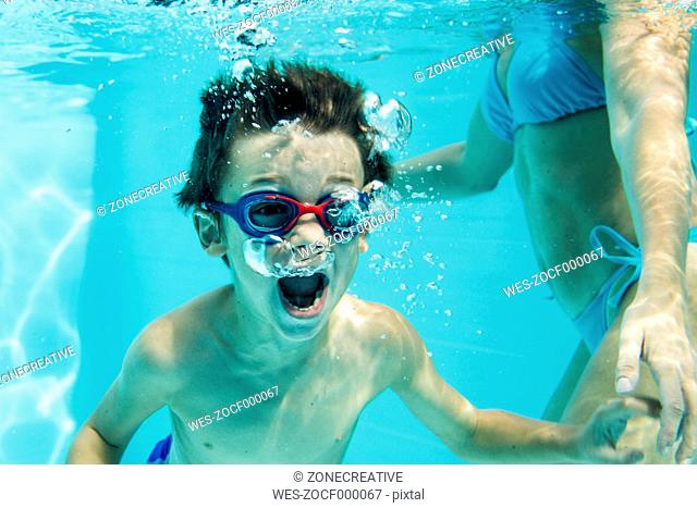 Young boy under water, air bubbles