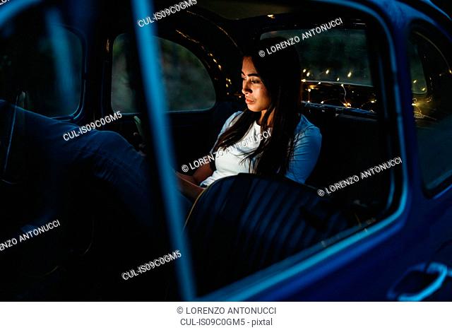Woman using smartphone inside car