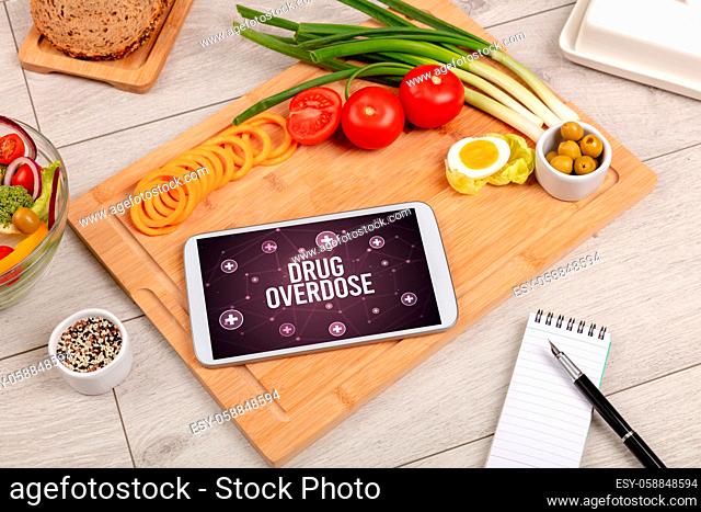 DRUG OVERDOSE concept in tablet pc with healthy food around, top view
