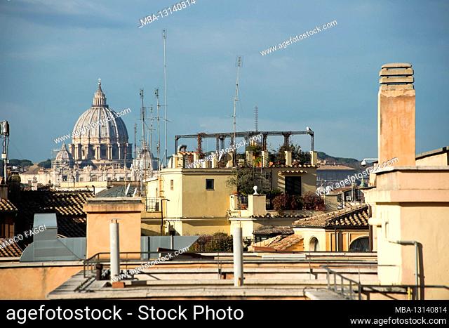 City view with roofs, antennas and chimneys, in the background St. Peter's Basilica