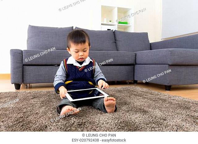Asian baby boy using tablet at home