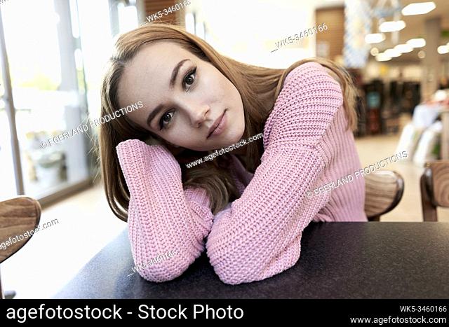 Young woman sitting at table in cafe