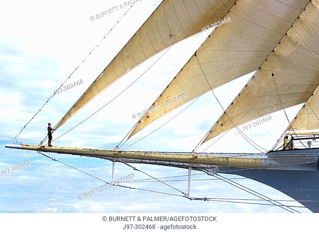 Star Clipper bow with the master rigger checking the rigging while at full sail. Honduras (Caribbean)
