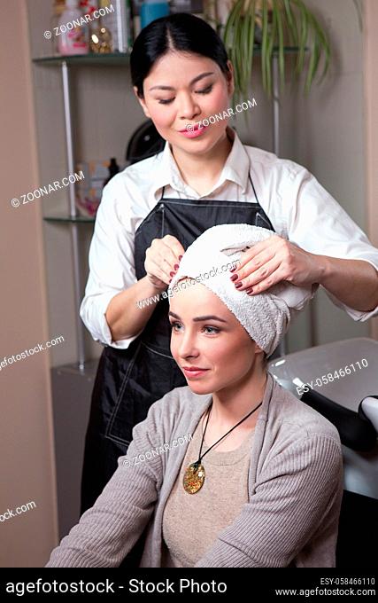 Beautiful lady sitting inchair after having her hair washed in hairdressing saloon. Barber girl preparing hair for haircut
