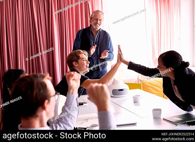 Business people high fiving during business meeting