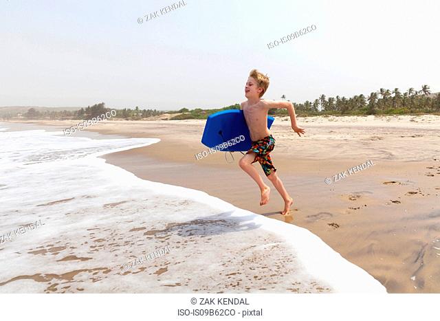 Boy running on beach, Goa, India, Asia