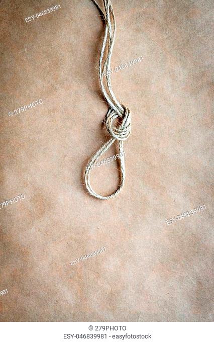 concept hangman's knot on kraft paper backgroun close up soft light top view