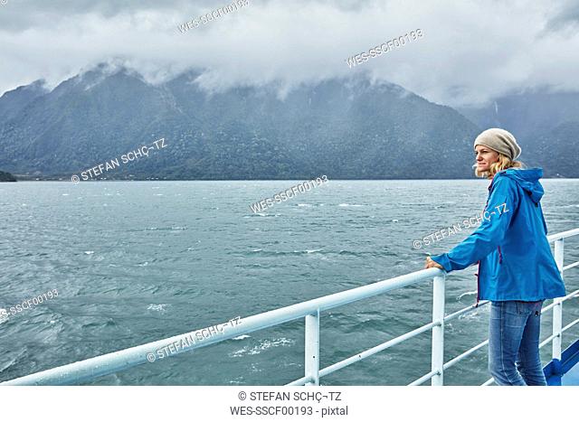 Chile, Hornopiren, woman standing at rail of a ferry looking at fjord