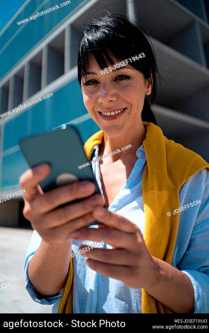 Smiling mature businesswoman with mobile phone