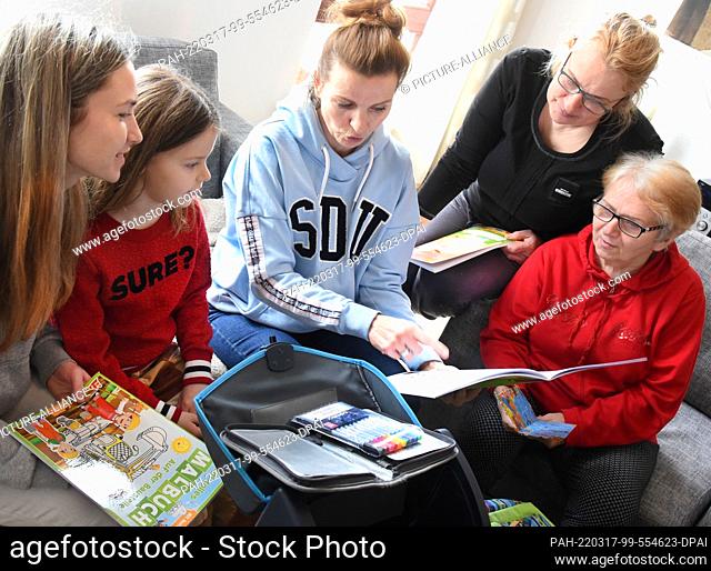15 March 2022, Saxony, Bad Düben: In her vacation apartment, physiotherapist Nicole Großmann (3rd from left) unpacks the school bags she brought with her with...