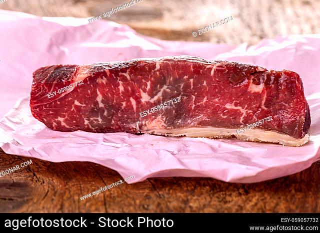 Rohes Steak auf rosa Papier