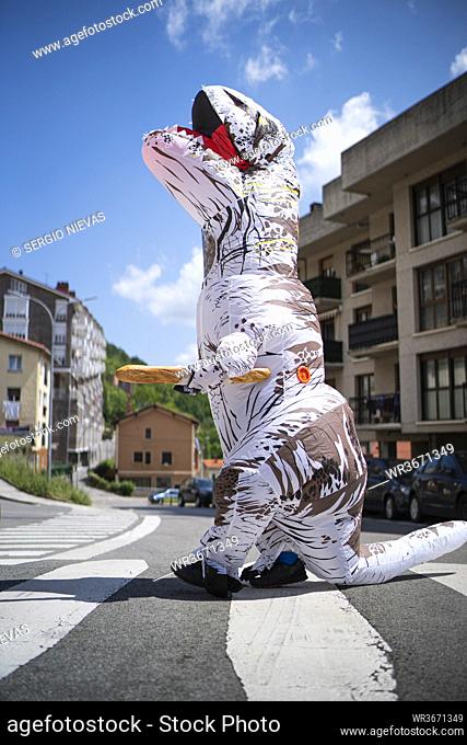 Large toy dinosaur with bread walking on zebra crossing against sky in city