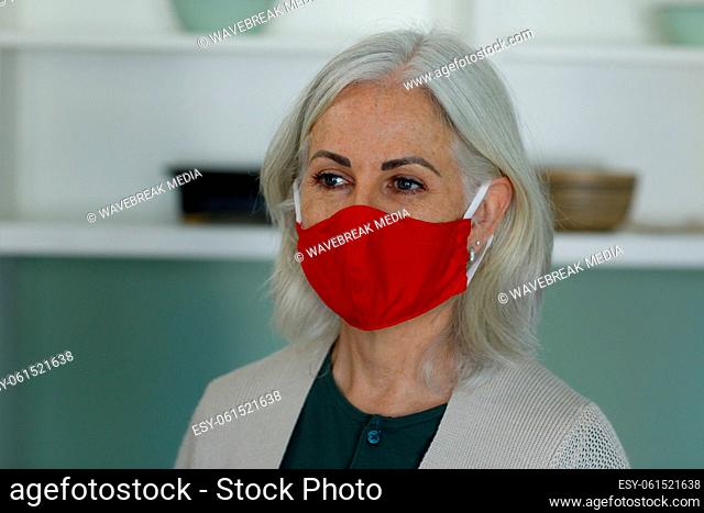 Senior caucasian woman wearing face mask at home