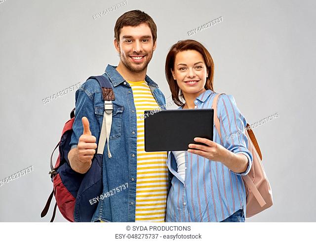 happy couple of tourists with tablet computer