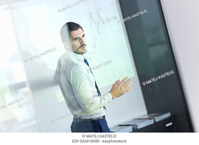 Business man making a presentation in front of whiteboard. Business executive delivering a presentation to his colleagues during meeting or in-house business...