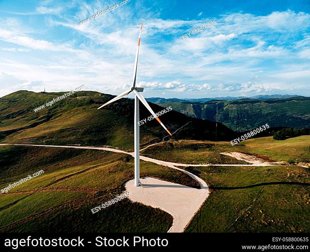 Beautiful bright photo of the wind generator in the field with the road. High quality photo