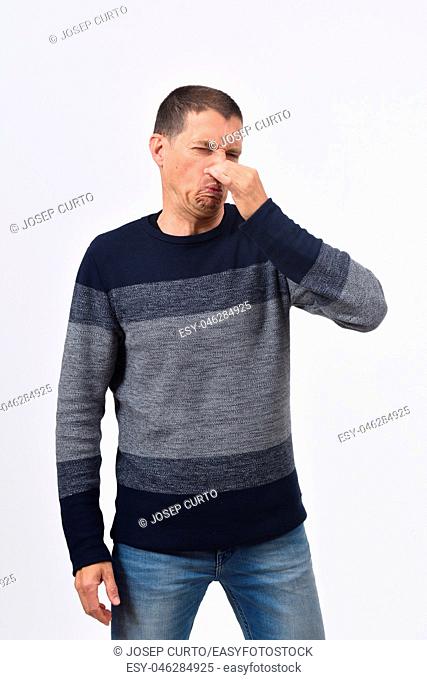 man who covers his nose with his fingers because it makes an smell bad
