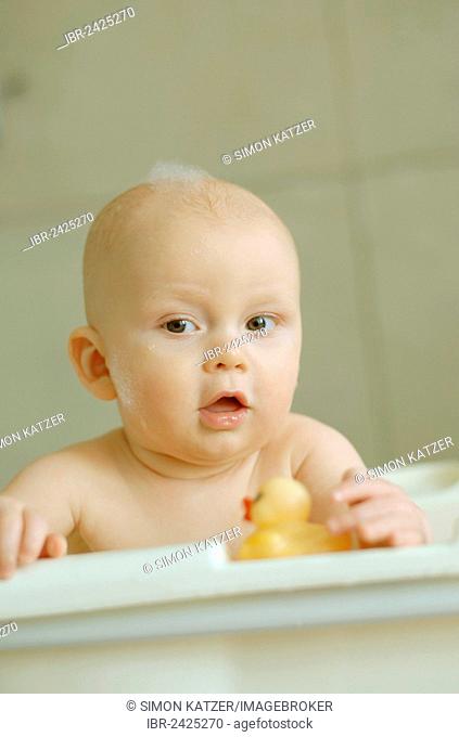 Baby in a bath with foam on his head