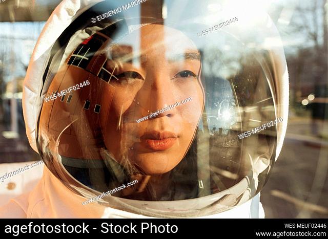 Female astronaut looking away wearing helmet during sunny day