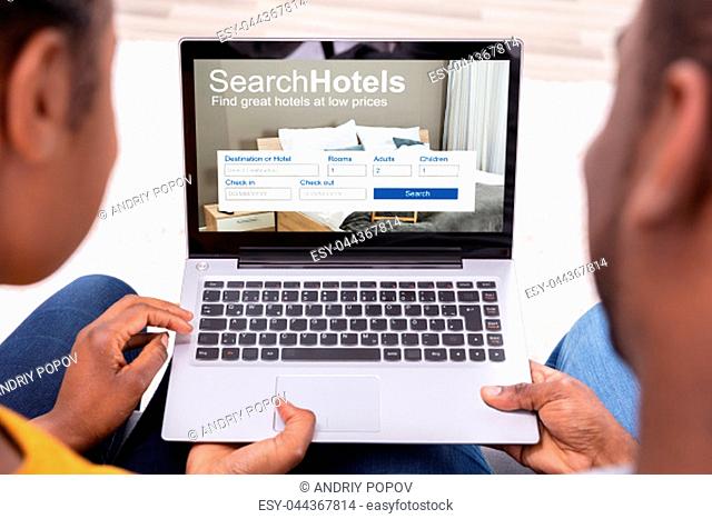 Close-up Of A Couple Searching Hotels With Low Prices On Laptop