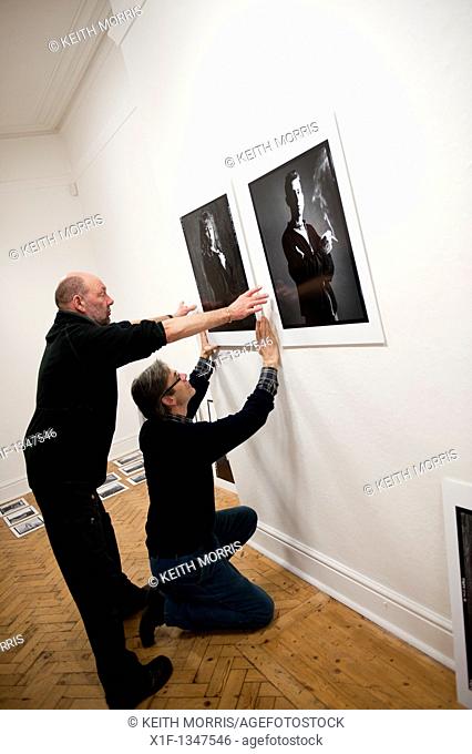 Setting up an exhibition of portrait photographs in an Art gallery, UK