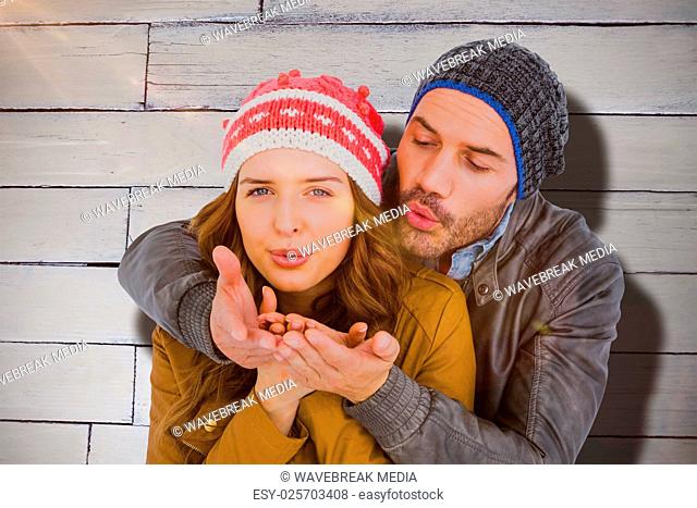 Composite image of happy young couple blowing kiss