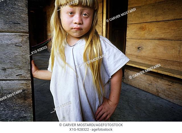 Albino Lacandon Indian Hach Winik boy Chan Bor standing at the doorway to his house in the village of Nah‡, Mexico