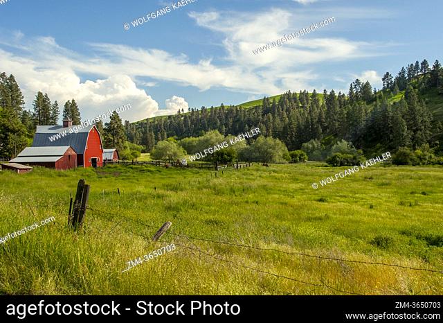 A red barn in a valley in Whitman County in the Palouse near Pullman, Eastern Washington State, USA