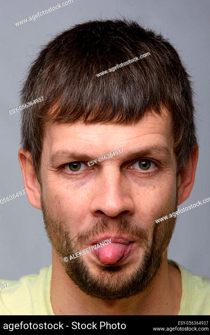 Portrait of a man of European appearance showing tongue, close-up