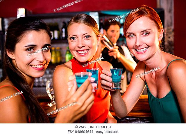 Female friends enjoying tequila in night club