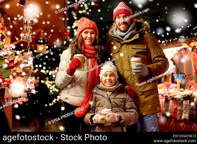 family with takeaway drinks at christmas market