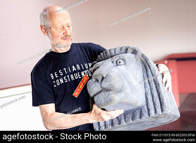 14 October 2021, Lower Saxony, Schöningen: Artist Alexander Reichstein stands in the Schöningen Research Museum with a model of a lion's head. From 16