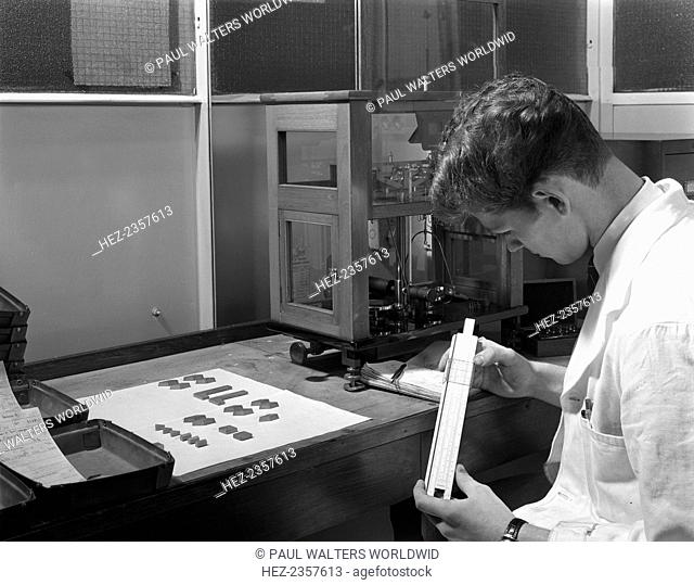 Lab technician with a slide rule, Edgar Allen's steel foundry, Sheffield, South Yorkshire, 1962. Before the invention of cheap electronic calculators