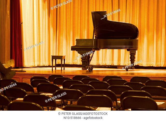 Grand piano on the stage of an empty auditorium