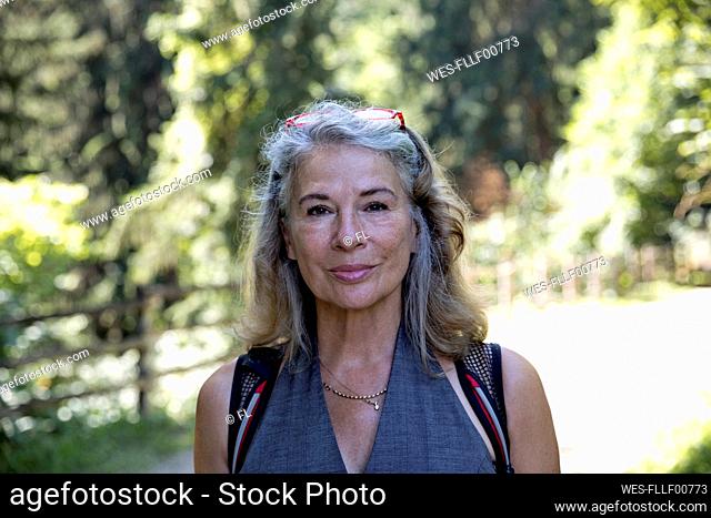 Smiling senior woman with gray hair on sunny day
