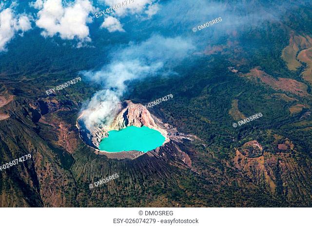 Aerial photo of active volcano Ijen in East Java - largest highly acidic crater lake in world with turquoise sulphuric water. Site of sulfur mining